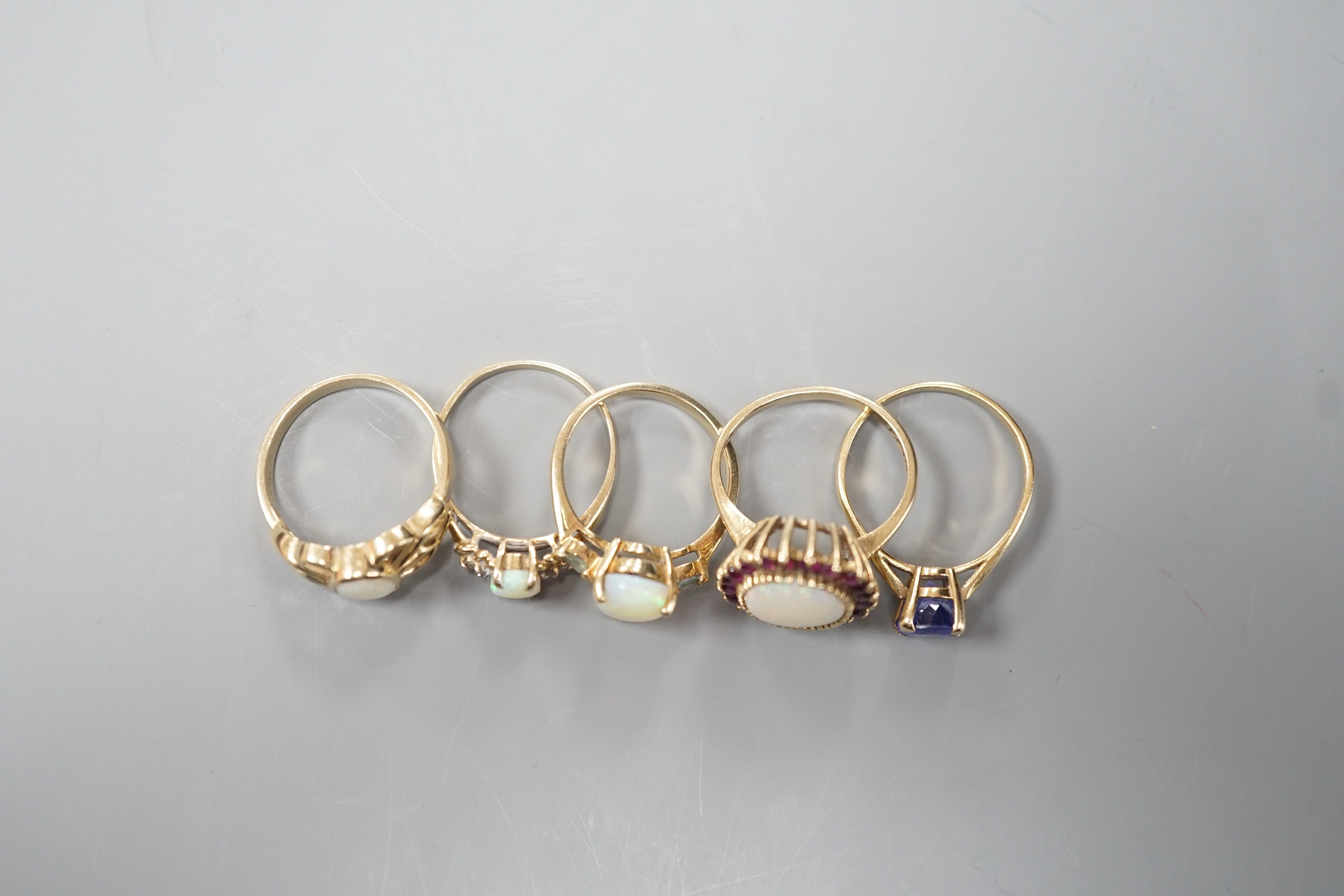 Five assorted modern 9ct gold and gem set dress rings, including white opal and garnet oval cluster, white opal and diamond chip and single stone white opal